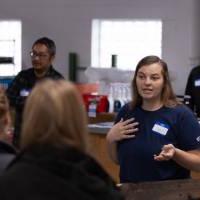 A person talking to a group of students at a service site